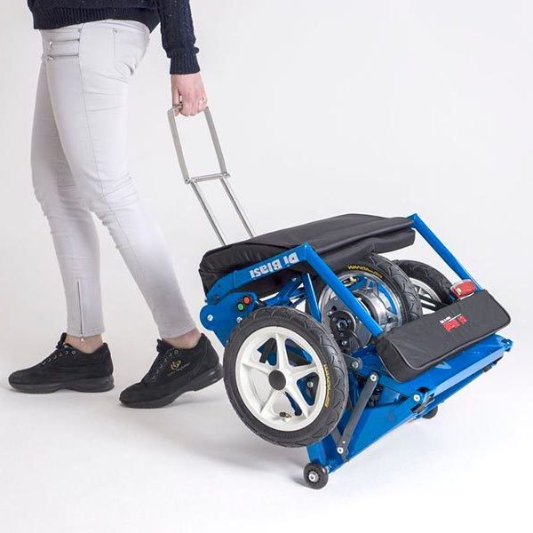 Der blaue R30 Elektroscooter wird zusammengefaltet von einer Frau gezogen.